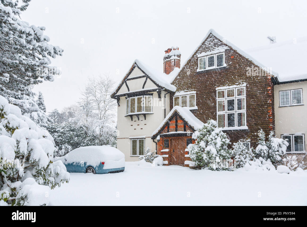 Auto blu parcheggiato nel comando di un grande Tarrant house di Woking, Surrey, Regno Unito ricoperto di neve durante forti nevicate in inverno Foto Stock