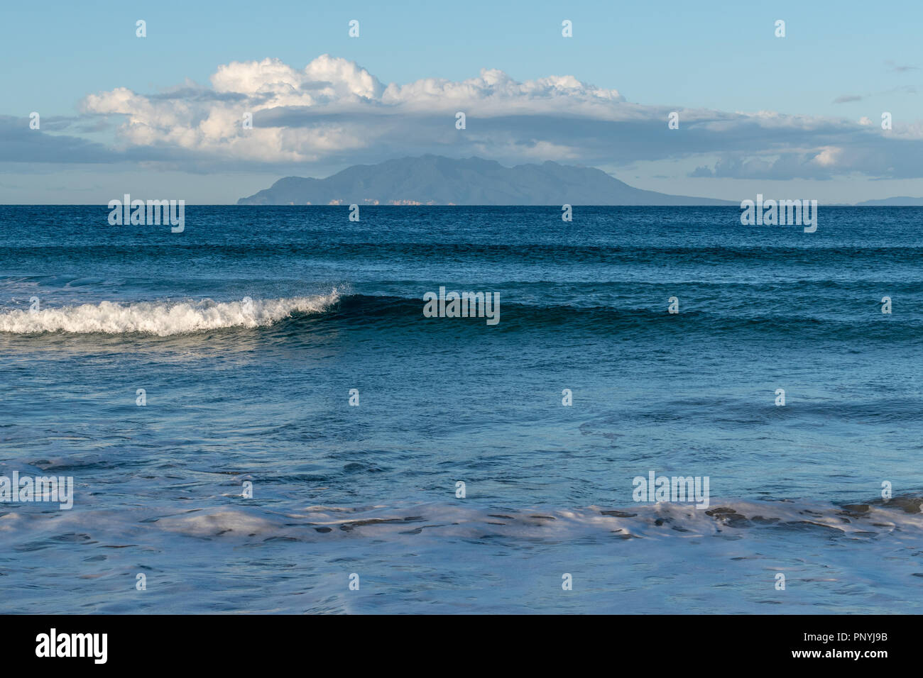 Bianco onda crestato che scorre dolcemente verso l'interno verso la riva Foto Stock