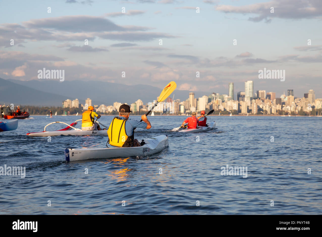 Vancouver, BC, Canada - 30 agosto 2018: persone racing su paddle boards e Surf Ski durante una vibrante estate tramonto. Foto Stock