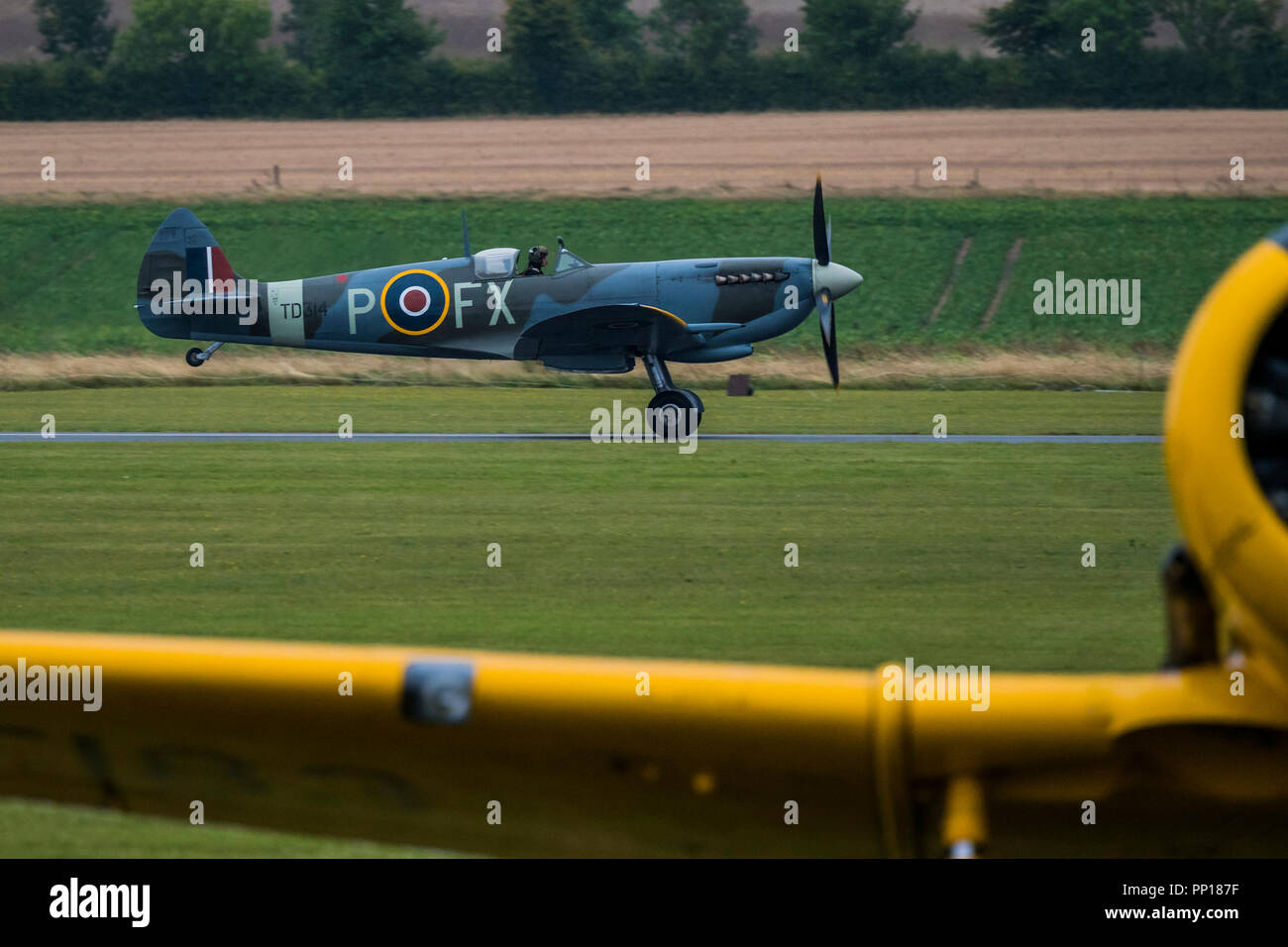 Duxford, UK. Il 22 settembre, 2018. 18 Spitfires decollo dietro altri piani classico come questo giallo Harvard, dall'erba pista di atterraggio per aerei per la finale flypast - Il Duxford Battle of Britain Air Show è un finale per il centenario della Royal Air Force (RAF) con una celebrazione di cento anni di storia di RAF e una visione del proprio futuro innovative funzionalità. Credito: Guy Bell/Alamy Live News Foto Stock