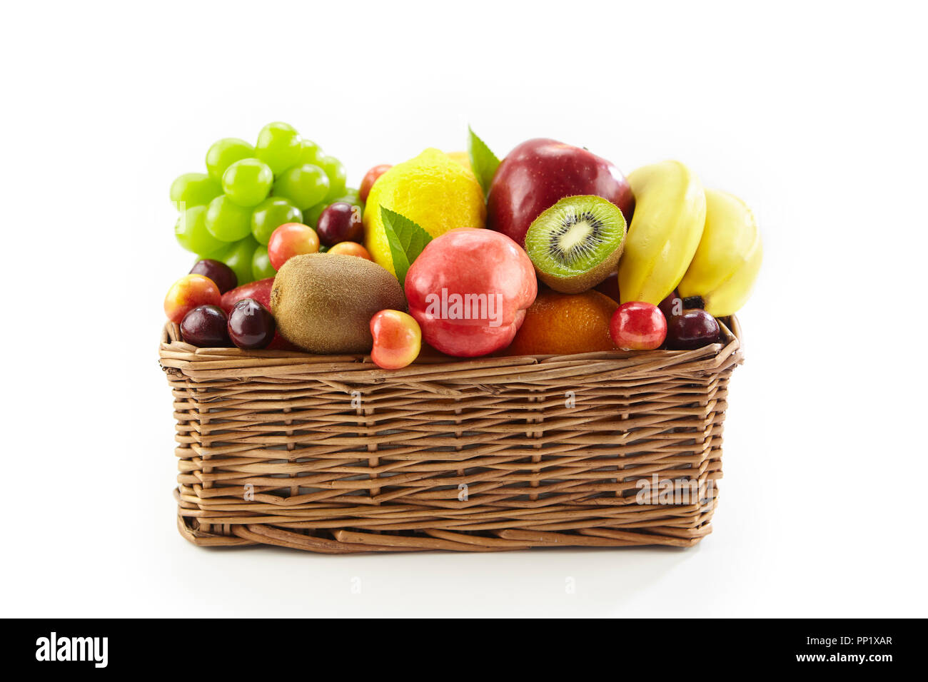 Un assortimento di frutta fresca in un cestino quadrato isolato su sfondo bianco, con copia spazio. Foto Stock