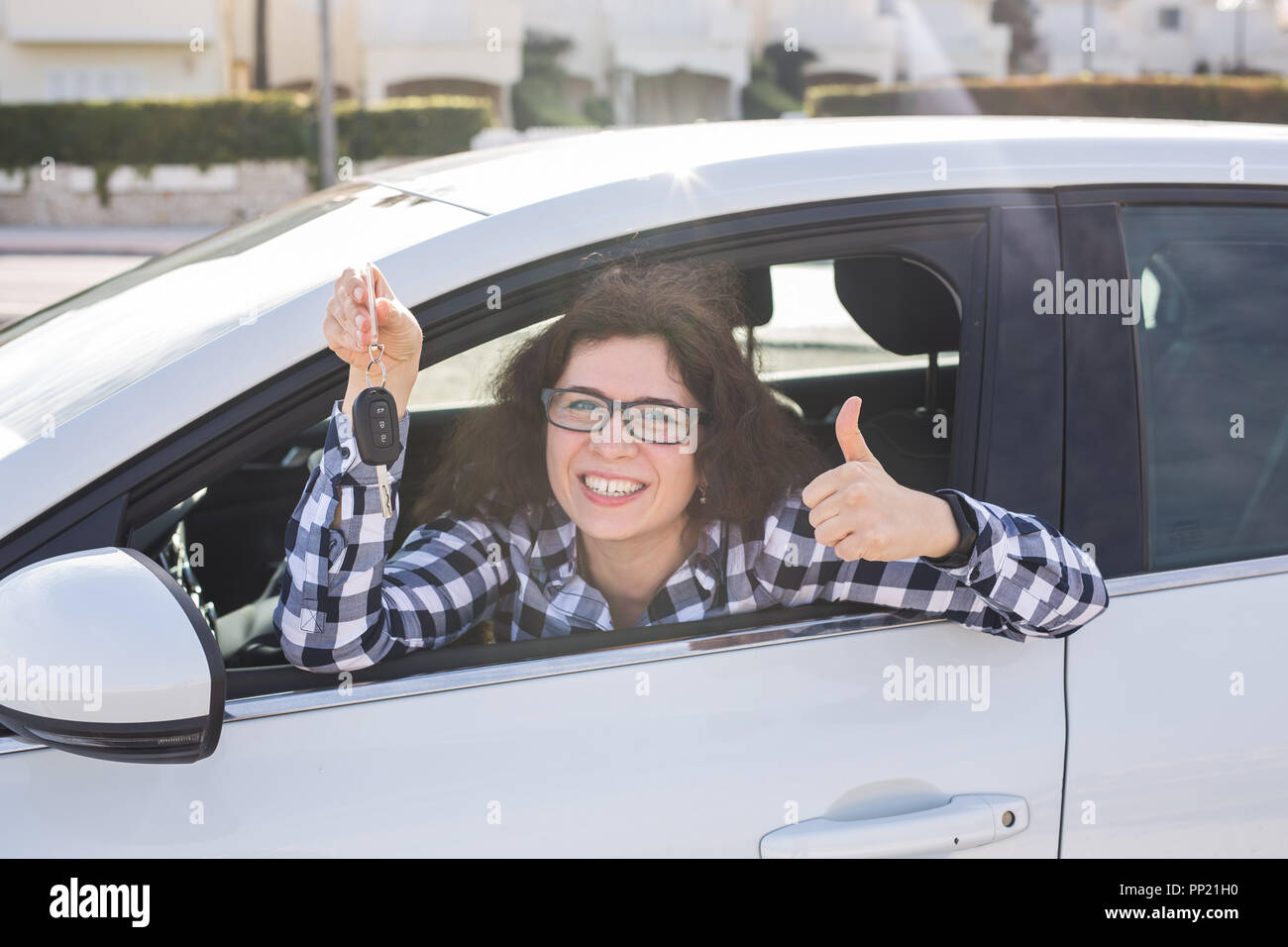 Giovane donna in auto mostra pollice in alto e il tasto Foto Stock