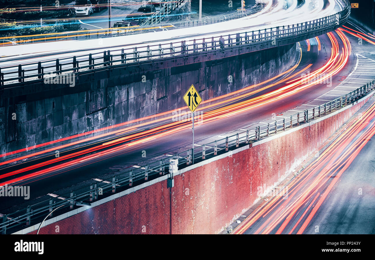 Una lunga esposizione foto di vetture in movimento sentieri di luce, tonificazione del colore applicato, New York City, Stati Uniti d'America. Foto Stock