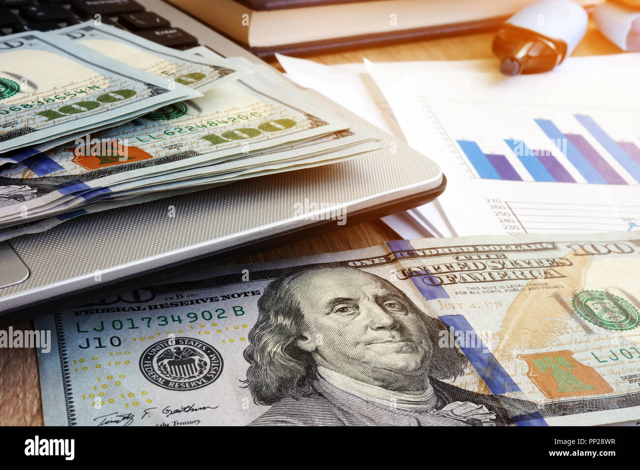 In contanti su un computer portatile e di documenti finanziari. La gestione degli investimenti. Il denaro. Foto Stock