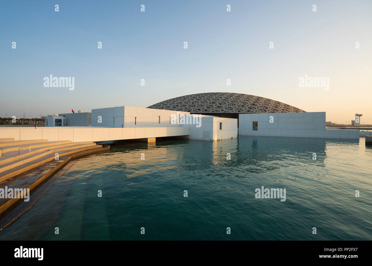 Esterno vista serale del Louvre Abu Dhabi a Saadiyat isola il distretto culturale di Abu Dhabi, negli Emirati Arabi Uniti. Architetto Jean Nouvel Foto Stock