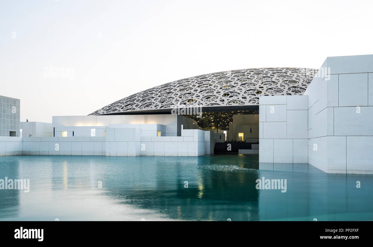 Esterno vista serale del Louvre Abu Dhabi a Saadiyat isola il distretto culturale di Abu Dhabi, negli Emirati Arabi Uniti. Architetto Jean Nouvel Foto Stock