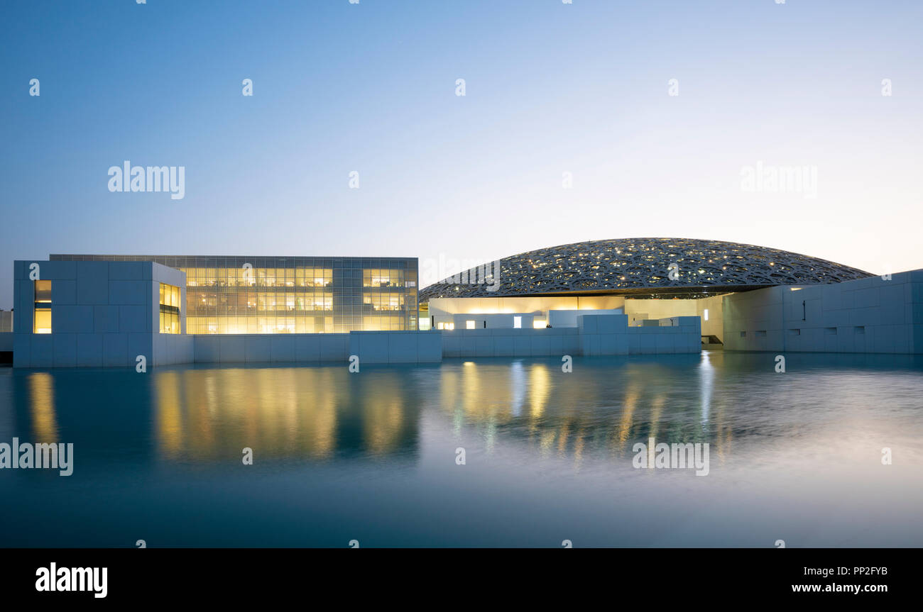 Esterno vista serale del Louvre Abu Dhabi a Saadiyat isola il distretto culturale di Abu Dhabi, negli Emirati Arabi Uniti. Architetto Jean Nouvel Foto Stock