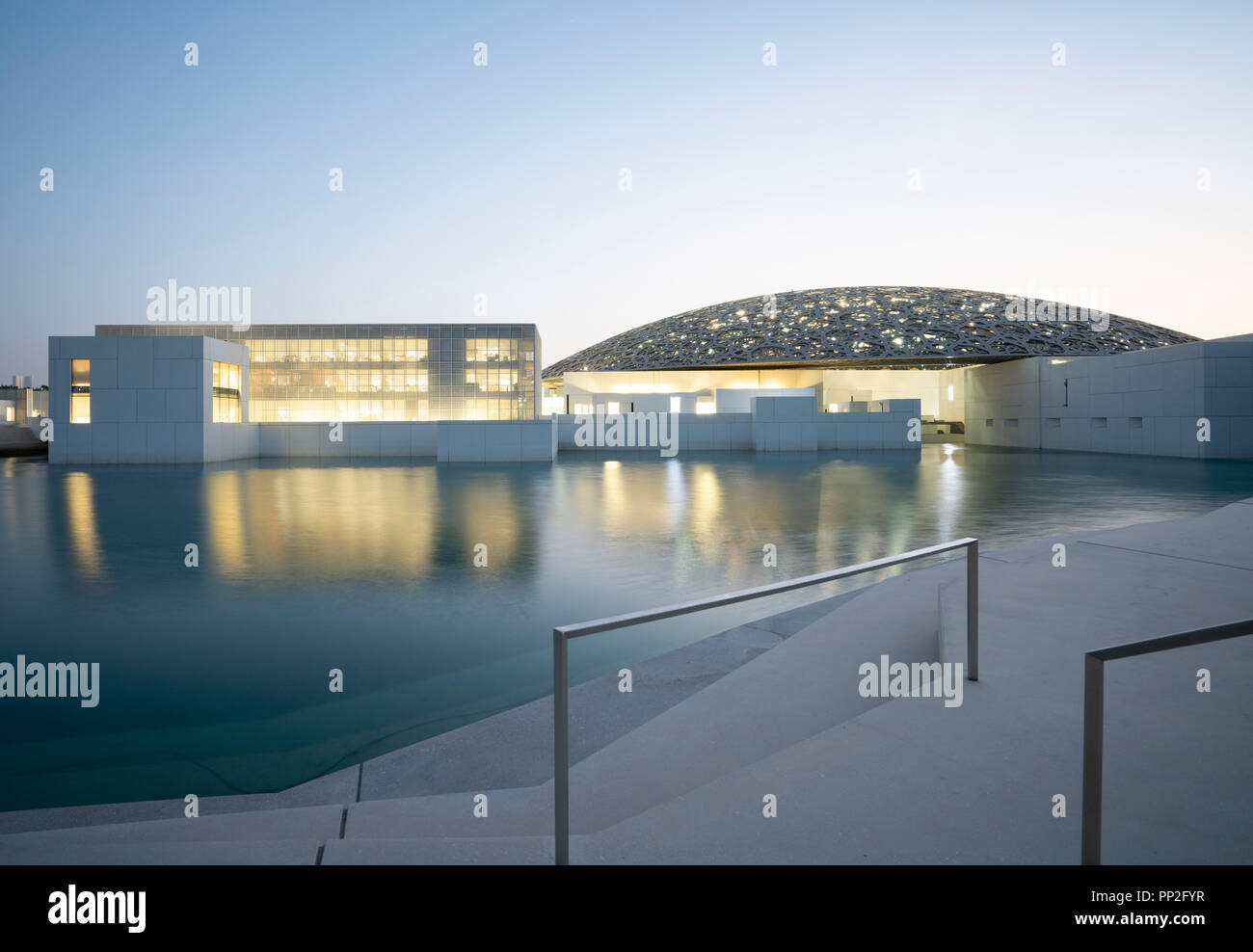 Esterno vista serale del Louvre Abu Dhabi a Saadiyat isola il distretto culturale di Abu Dhabi, negli Emirati Arabi Uniti. Architetto Jean Nouvel Foto Stock