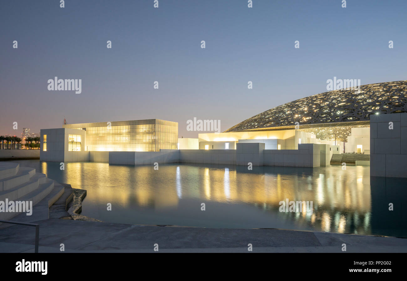Esterno vista serale del Louvre Abu Dhabi a Saadiyat isola il distretto culturale di Abu Dhabi, negli Emirati Arabi Uniti. Architetto Jean Nouvel Foto Stock
