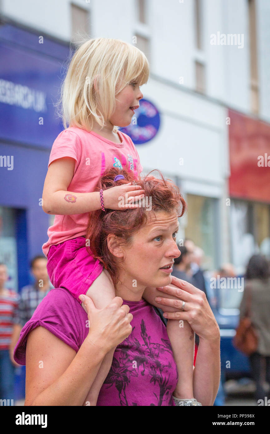 Ragazza giovane ottenendo un piggy back da sua mamma. Foto Stock