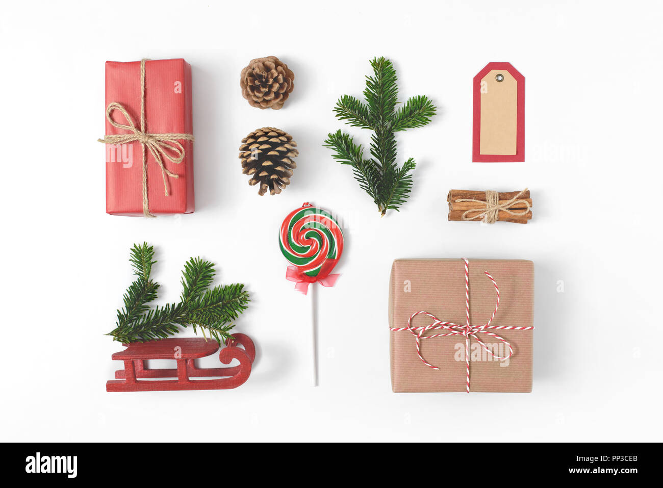 Set di vari dettagli di Natale: regali, rami di pino, giocattoli su sfondo bianco. Vista superiore, piatto laici. Foto Stock