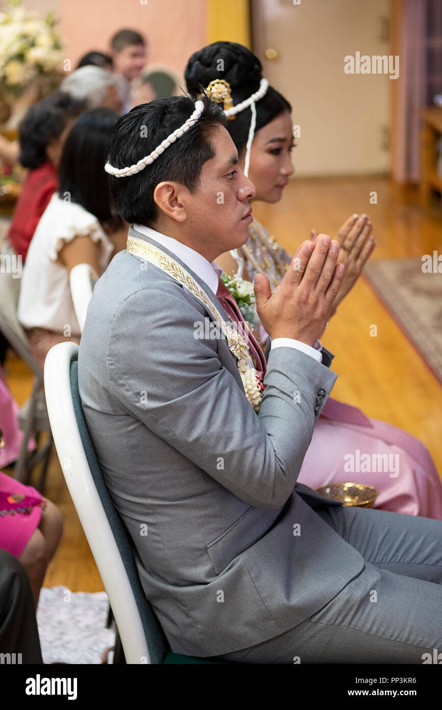 Un Buddista brode e lo sposo durante il loro servizio di nozze in un tempio nel Queens, a New York. Essi sono collegati con il filetto sacred. Foto Stock