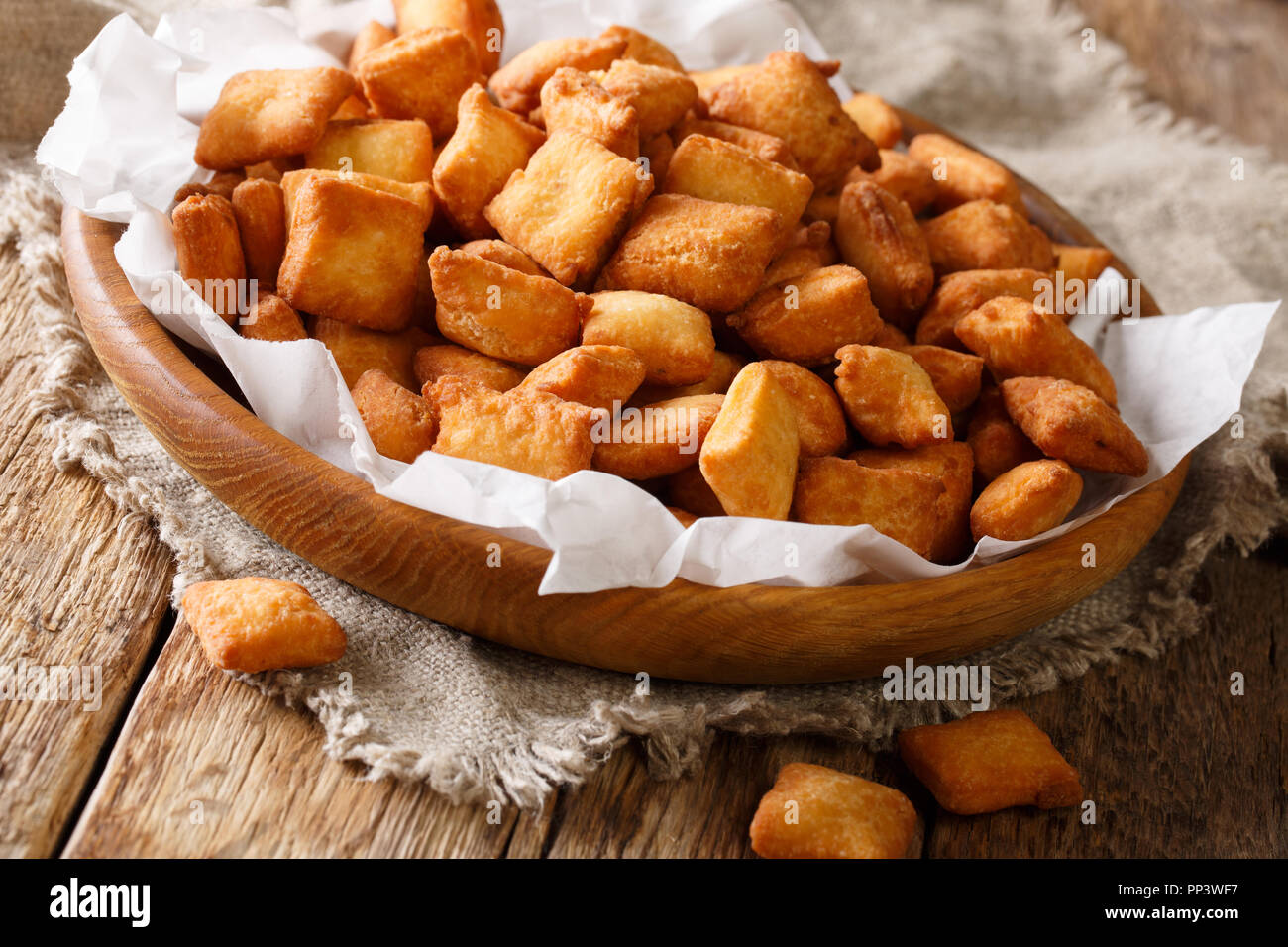 Golden snack nigeriano Chin Chin di fritte di pasta croccante con una noce moscata close-up in una ciotola sul tavolo orizzontale. Foto Stock