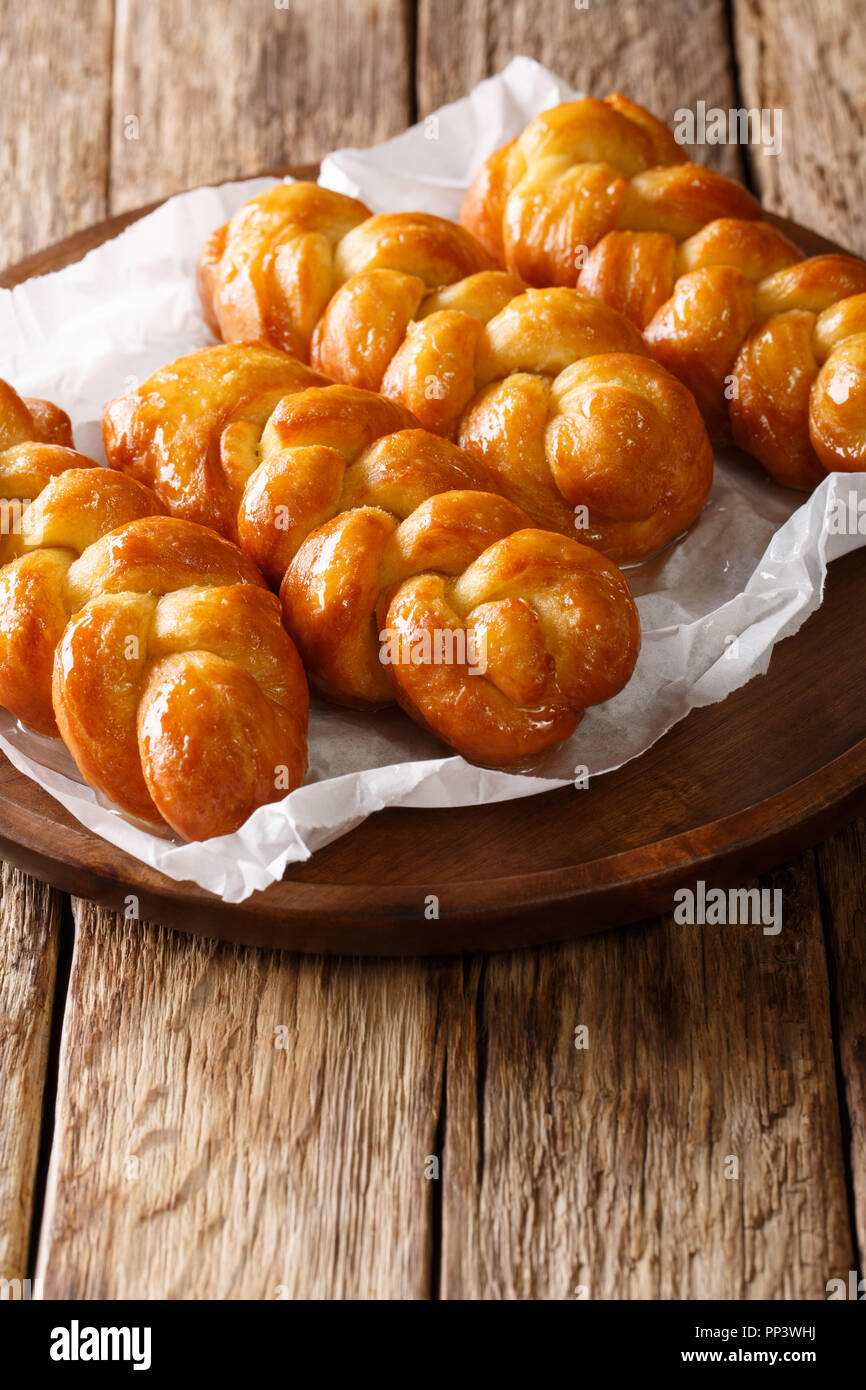 Koeksisters tradizionale South African sticky ciambella dolce, appiccicosa, croccante e intriso di sciroppo, cucita con cannella, limone e zenzero close-up su una p Foto Stock