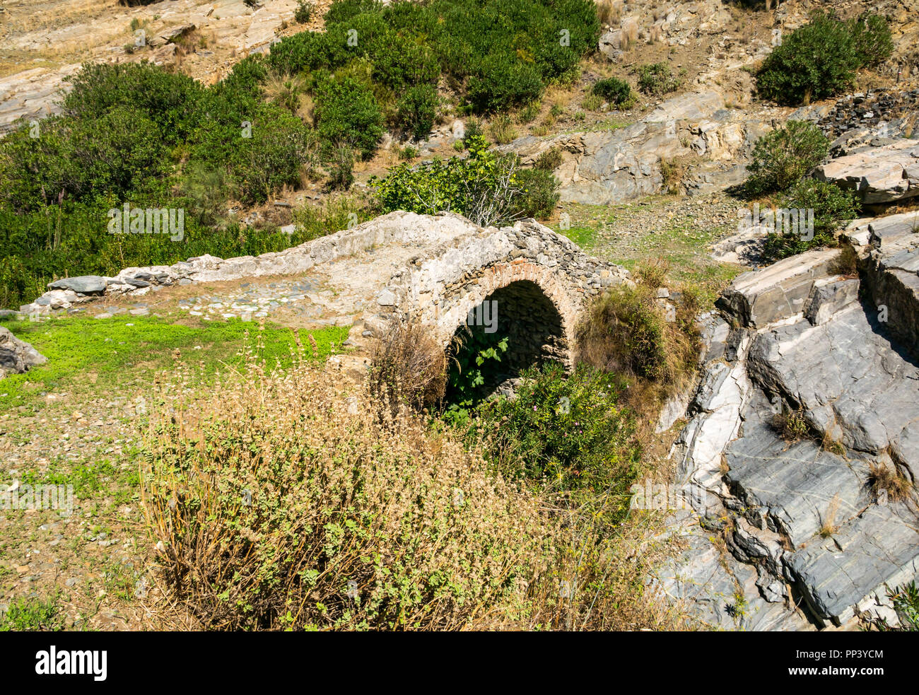 Il vecchio ponte romano in gola nel Sierras de Tejeda Parco naturale sul percorso Mujedar, Sedella, Axarquia, Andalusia, Spagna Foto Stock