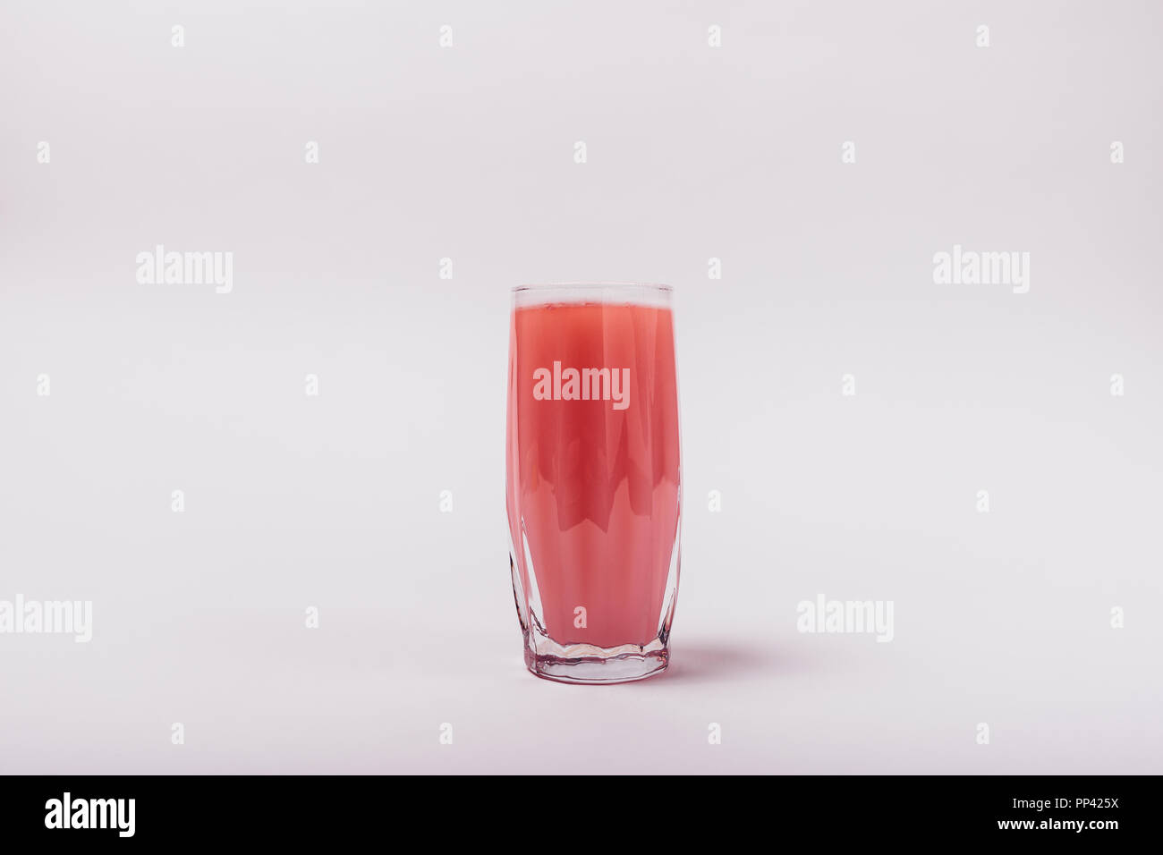 Proteina Pink Drink in vetro su sfondo bianco. Immagine minimale di sport nutrition supplemento disciolto in acqua, copia dello spazio. Foto Stock