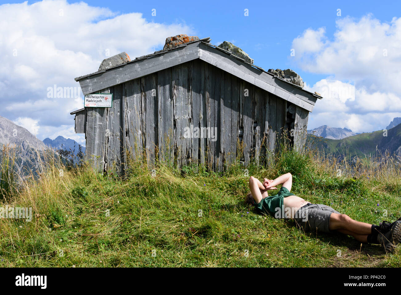 Holzgau: escursionista uomo in appoggio giacente presso il monte prato, capanna, Lechtal Valley, Tirol, Tirolo, Austria Foto Stock