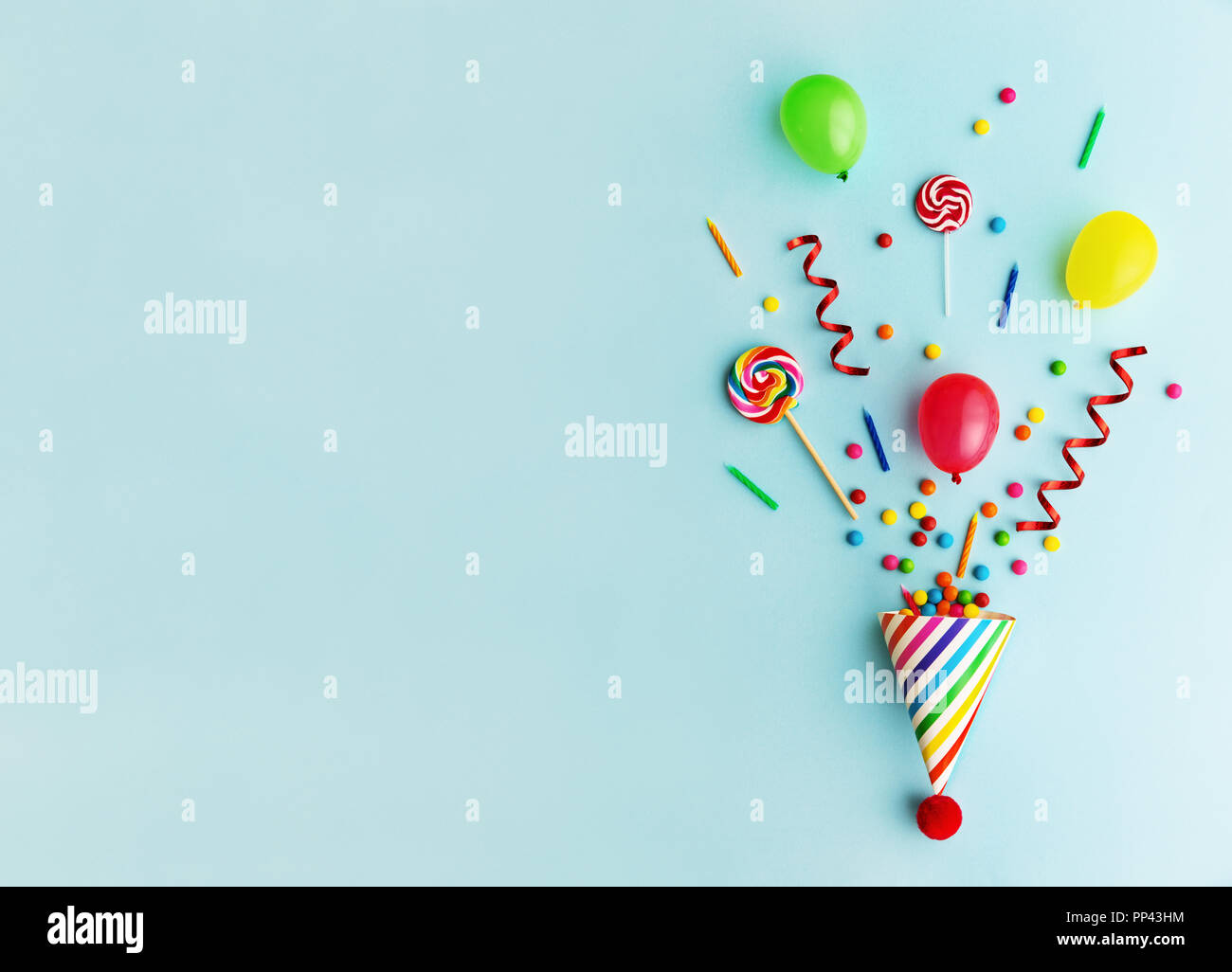 Cappellino con la caramella, palloncini e candeline di compleanno Foto Stock