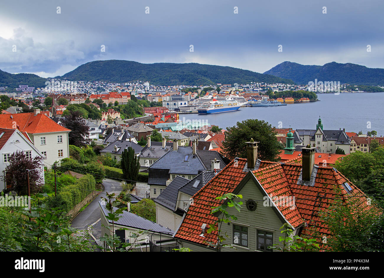 Vista di Bergen. Skyline, nuvole, Fjord, montagne, cityscape, bay, yacht, barche, traghetto, edifici storici, case, rosso sui tetti della città. Norvegia, Scandinavia, turismo, un punto di riferimento. Foto Stock