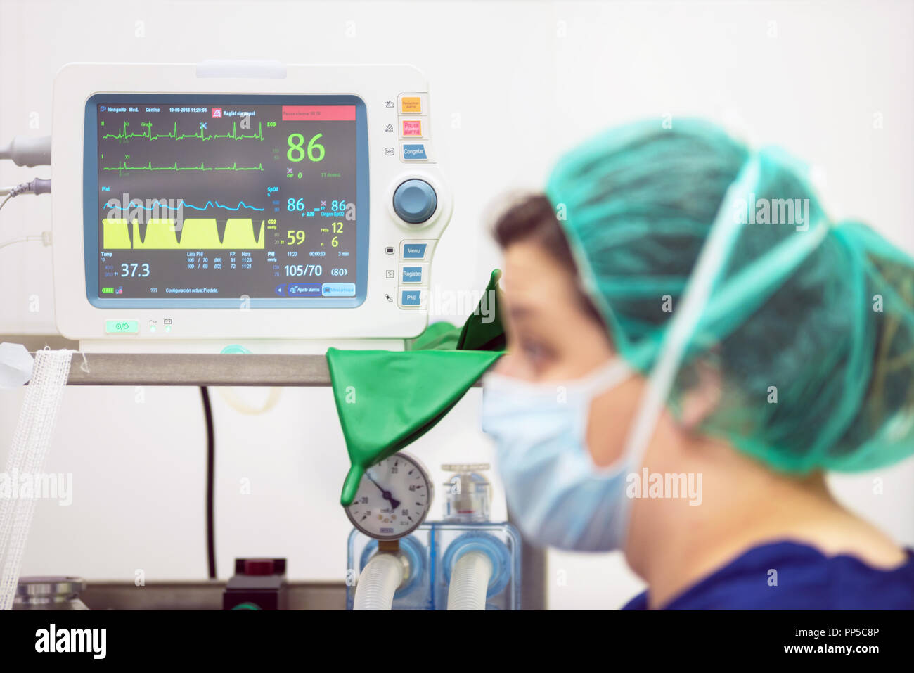 Medico Veterinario ritratto in sala operatoria. Monitoraggio anestesiologico in background Foto Stock