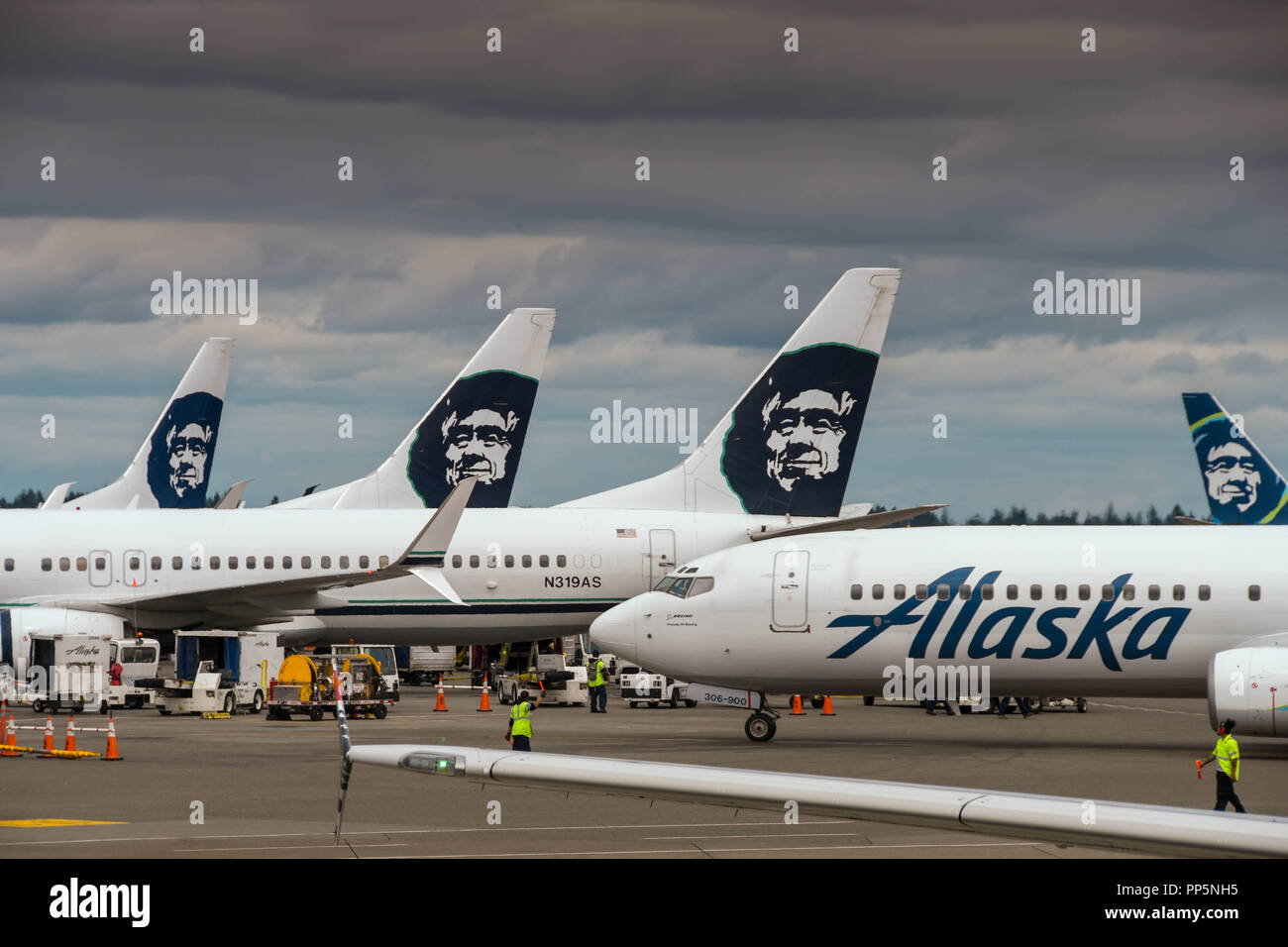 SEATTLE, WA - Giugno 2018: Alaskan Airlines Boeing 737 jet rullaggio passato le alette di coda della compagnia aerea altri aeromobili all'aeroporto di Seattle. Foto Stock