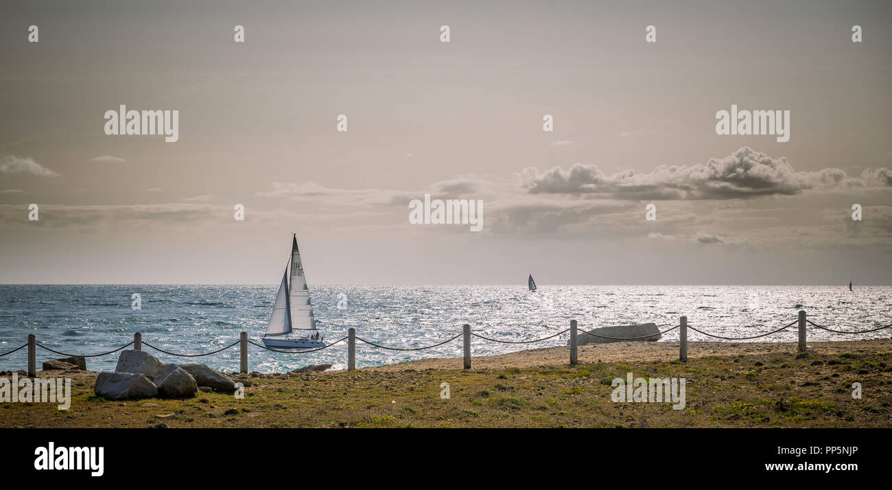 Un ampio angolo di visione di barche a vela e yacht off portland bill, il cielo è grigio con frammentaria della nuvola ma brillante luce evidenzia le creste d'onda. Foto Stock