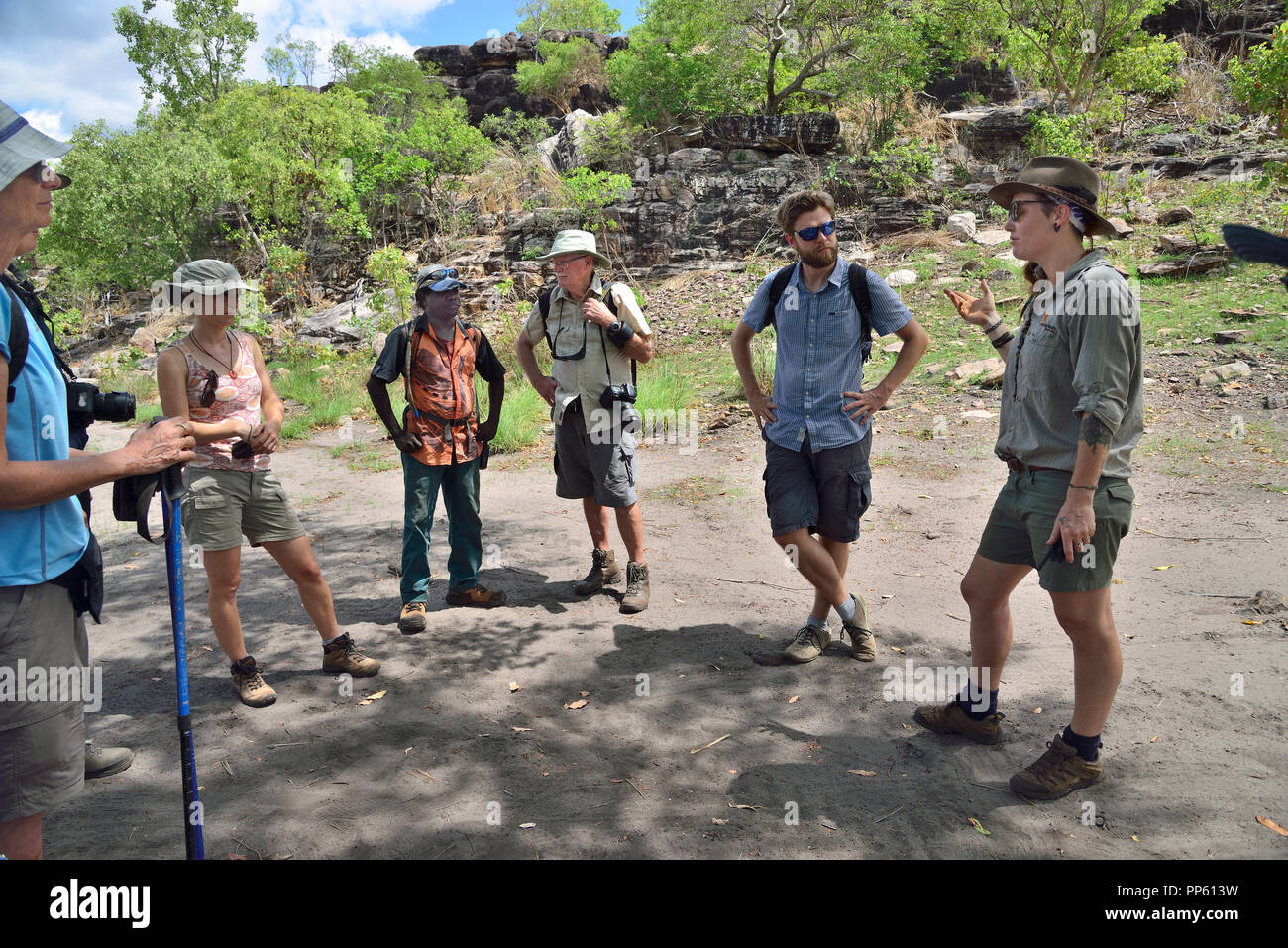 Gruppo di turisti con guida aborigena circa a piedi fino Injalak Hill (Long Tom Dreaming) di Arnhem Land, Northern Territory, estremità superiore, Australia Foto Stock