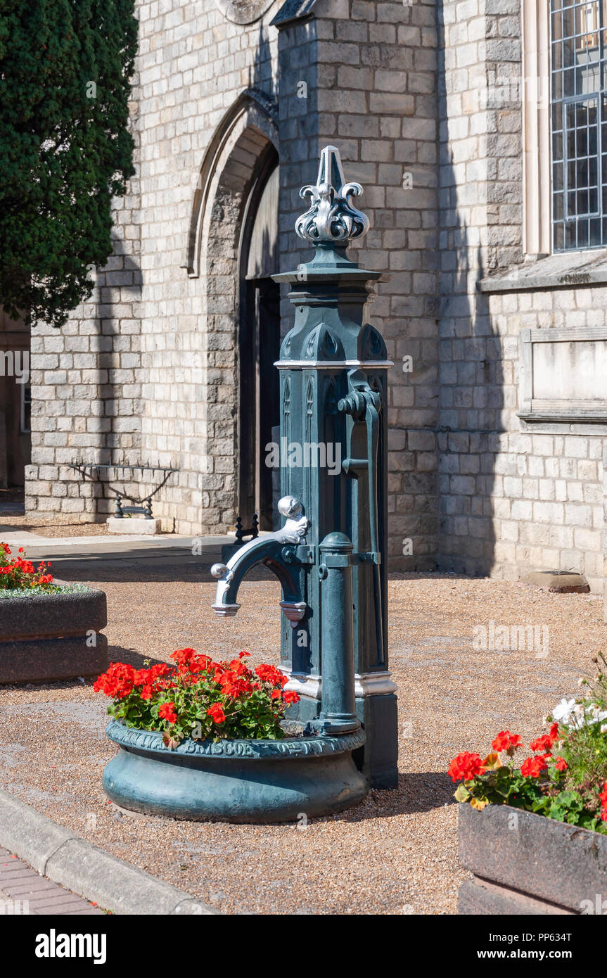 Vecchia Pompa acqua al di fuori la Chiesa di San Pietro, Windsor Street, Chertsey, Surrey, England, Regno Unito Foto Stock