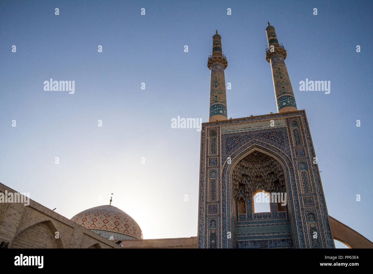 La moschea Jameh, con il suo distintivo piastrelle minareti, visto al tramonto. La moschea Jameh è uno dei simboli della città di Yazd, nel mezzo del deserto Foto Stock