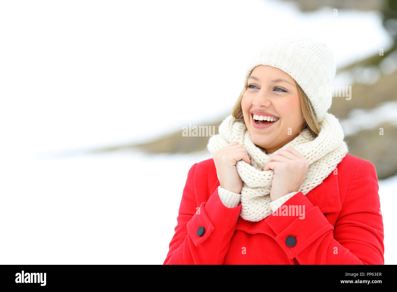 Happy woman in red godendo le vacanze invernali in una montagna innevata Foto Stock