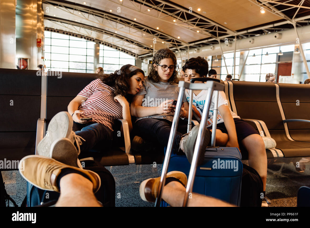 I giovani con lo smartphone in boarding gate lounge in aeroporto. Foto Stock