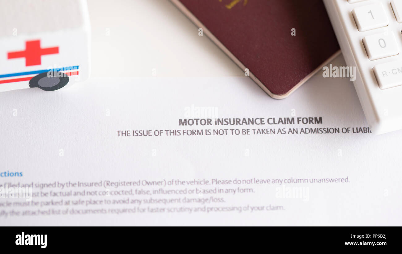 Assicurazione del motore modulo di reclamo sul tavolo con passaporto Foto Stock