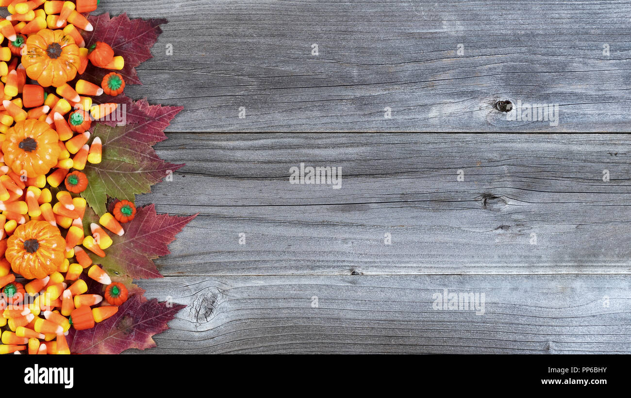 Bordo sinistro di Halloween di caramelle e autunno decorazioni rustiche tavole in legno Foto Stock