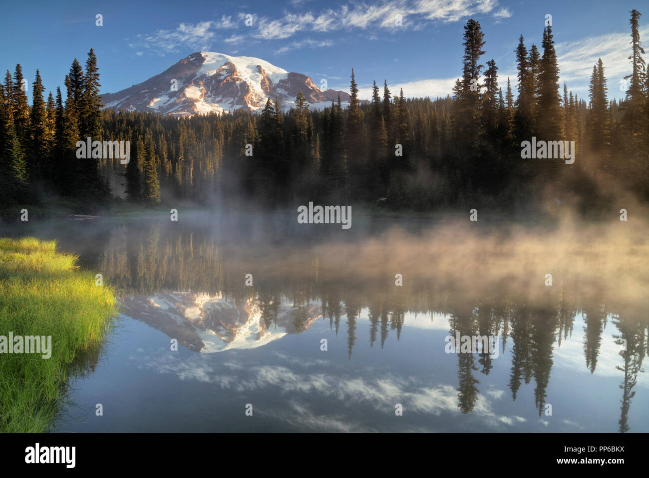 Primo bagliore di luce su Washington Mt Rainier dal appropriatamente chiamato laghi di riflessione in Mount Rainier National Park. Foto Stock