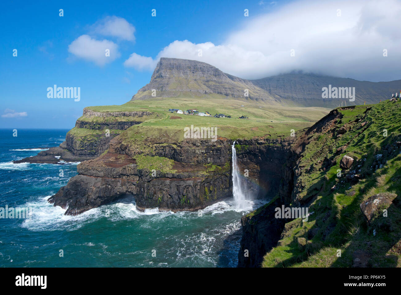 La cascata Mulafossur e il villaggio di Gasadalur. Funzionario Ministeriale isola. Isole di Faroe Foto Stock