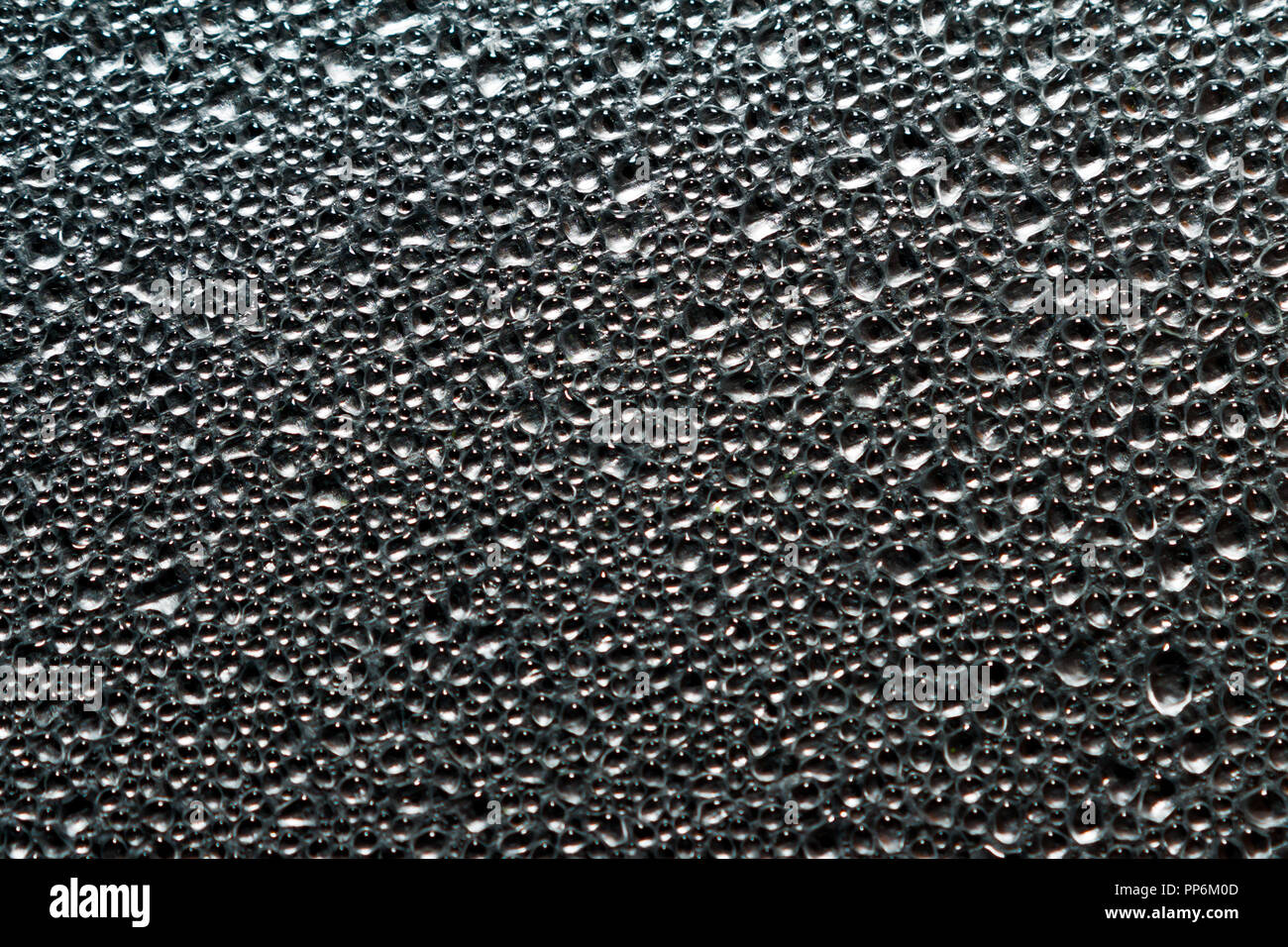 Sfondo astratto di vapore umido o goccioline di acqua sulla lamina di alluminio superficie. Macro vista dall'alto. Foto Stock
