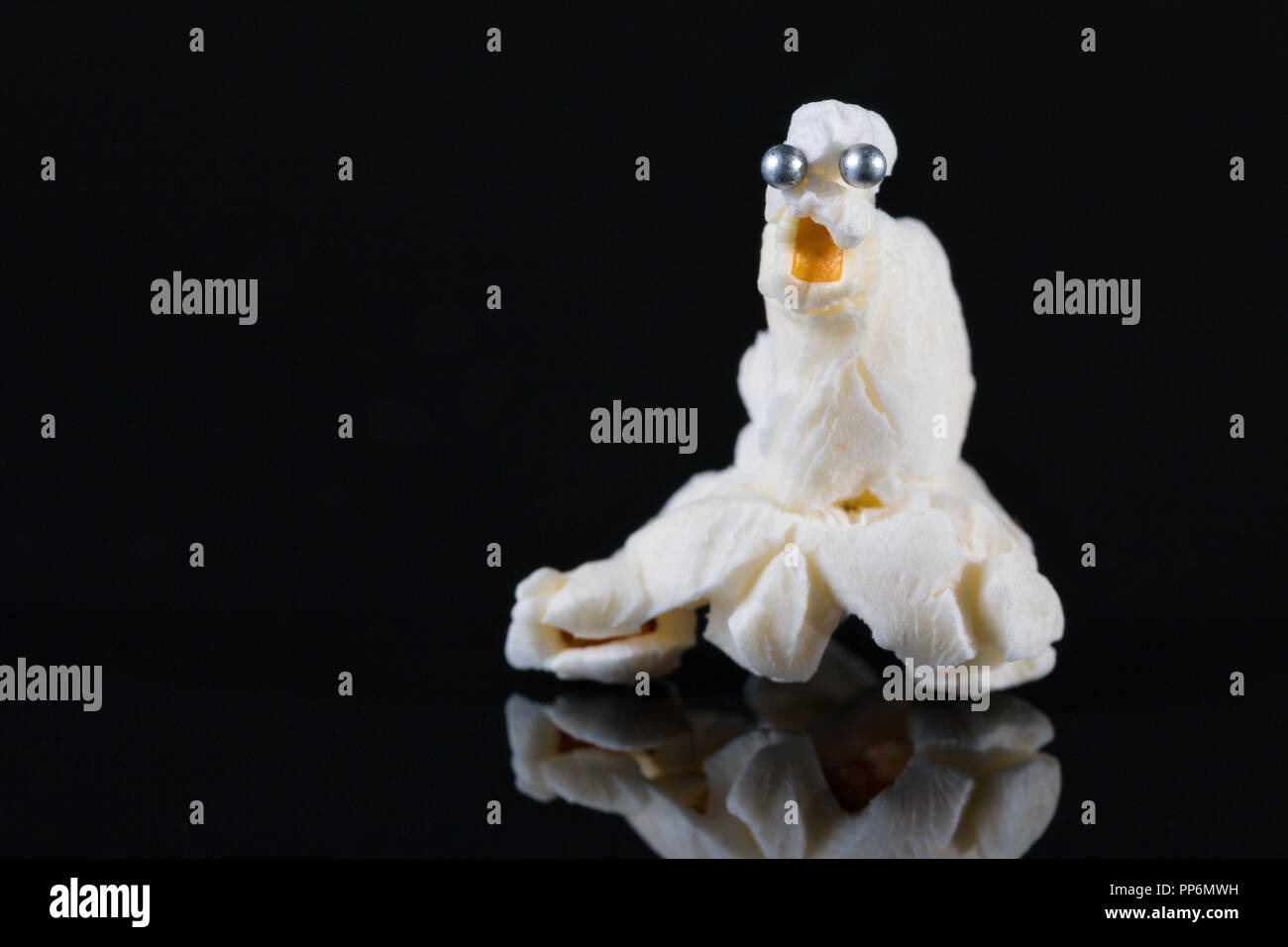 Divertimento Halloween popcorn guarnizione di polpo animale con pinhead per occhi su sfondo nero Foto Stock