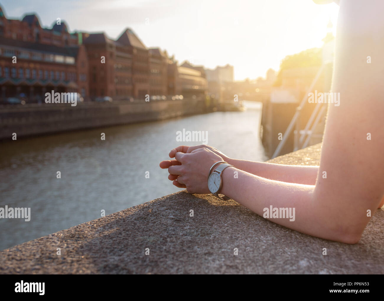 Vista parziale di donna in appoggio le sue braccia sulla parete quay Foto Stock