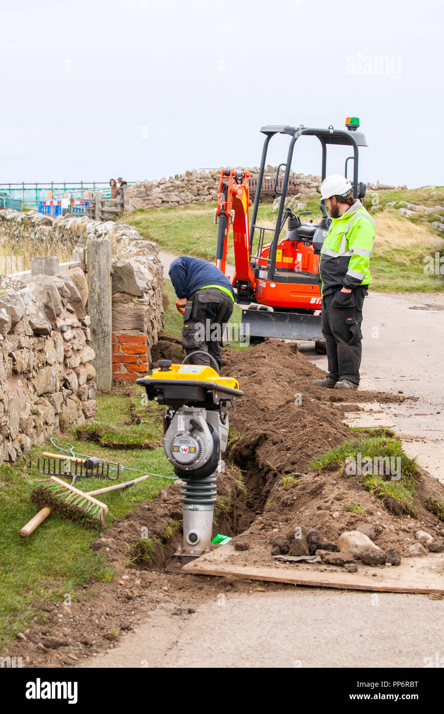 Gli ingegneri di Openreach installazione ad alta velocità in fibra ottica a banda larga per il castello sull'Isola di Lindisfarne o Isola Santa Northumberland Englang REGNO UNITO Foto Stock