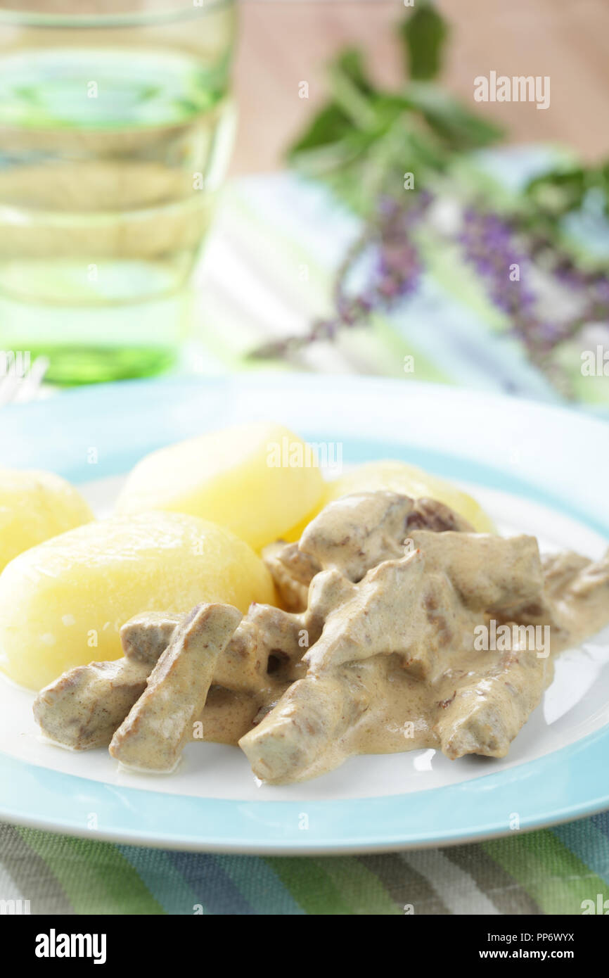 Carni bovine Stroganoff con patate bollite sulla piastra closeup Foto Stock