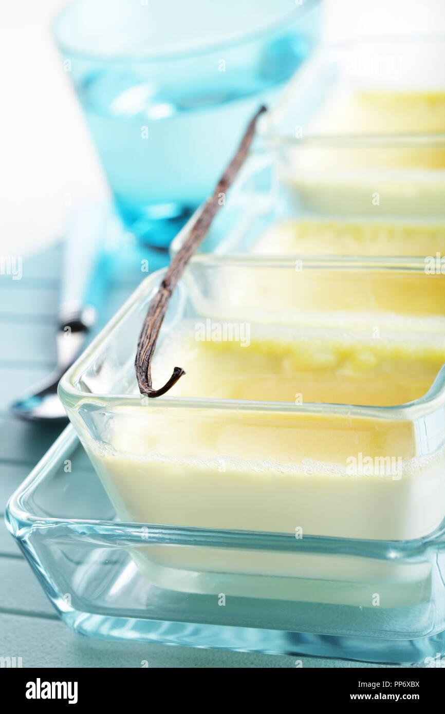 Creme brulee in piatti in vetro con il baccello di vaniglia Foto Stock