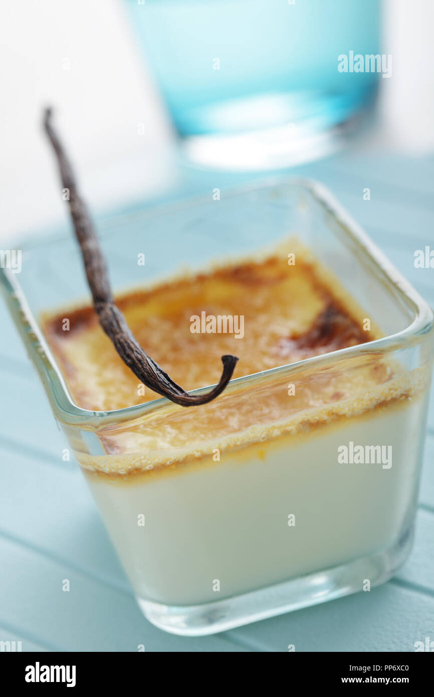 Creme brulee nel piatto di vetro con baccello di vaniglia Foto Stock