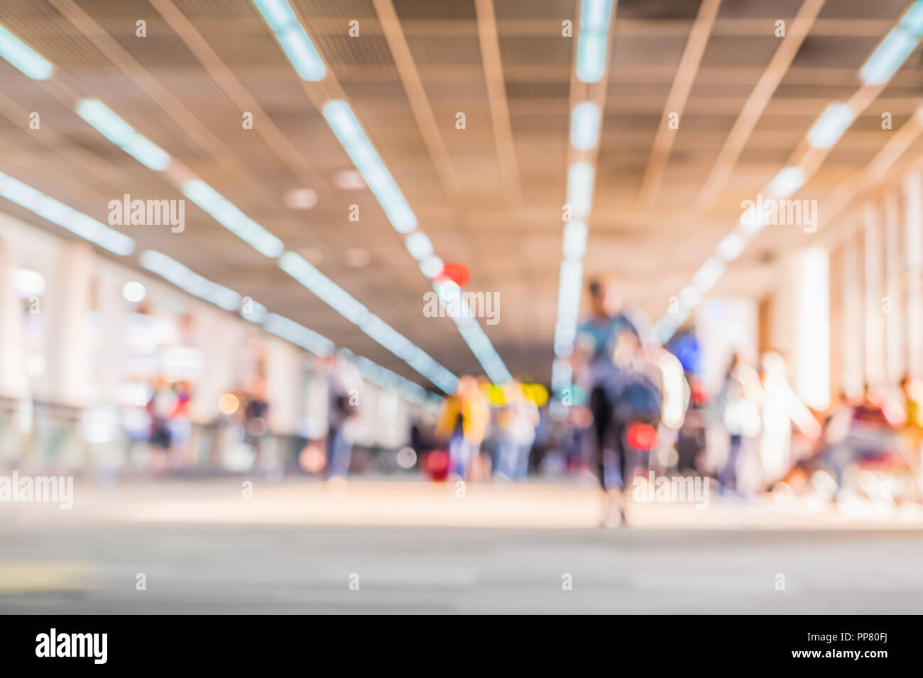Sfocare lo sfondo della folla di viaggiatori con bagaglio al Terminal Partenze Check-in in aeroporto con luce bokeh di fondo Foto Stock
