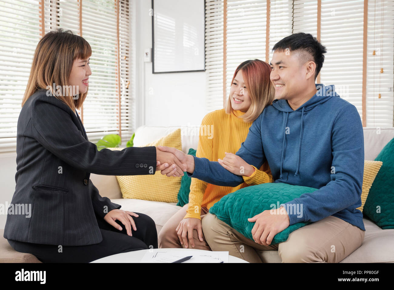 Asian giovane segno home contratto e handshake con agente immobiliare al soggiorno nella nuova casa.acquisto nuova casa real estate Foto Stock