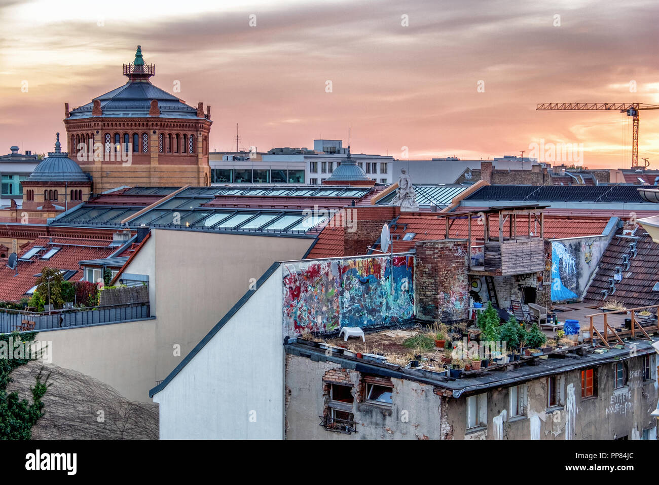 Berlin-Mitte. Vista sul tetto. Torre ottagonale e cupole di restaurato Postamt Post office building e il giardino sul tetto dell'edificio abbandonato al tramonto Foto Stock