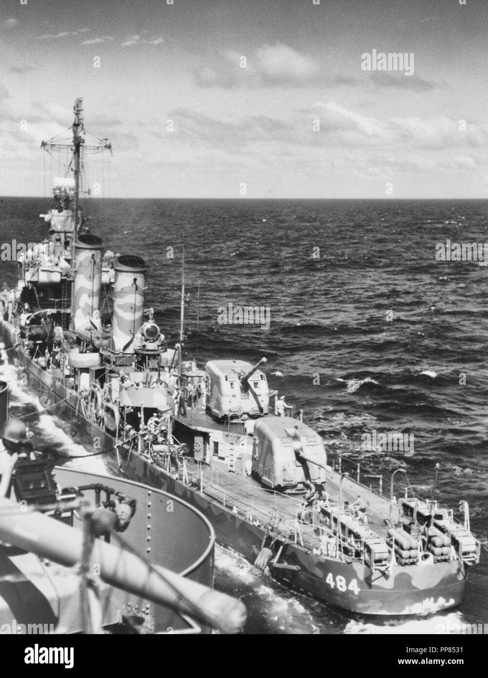 USS Buchanan (DD-484) effettua il rifornimento di carburante da USS Wasp (CV-7) mentre in rotta per il Guadalcanal-Tulagi area di invasione, 3 agosto 1942. Buchanan è dipinta di camuffamento di misura 12 (modificato). Nota le cariche di profondità in rack di poppa e su K-Guns, i parafanghi truccate lungo i suoi lati e il red flag di rifornimento in volo da lei foremast. Prendere nota anche delle 5/38 pistola a bordo di vespe, in basso a sinistra. Foto Stock