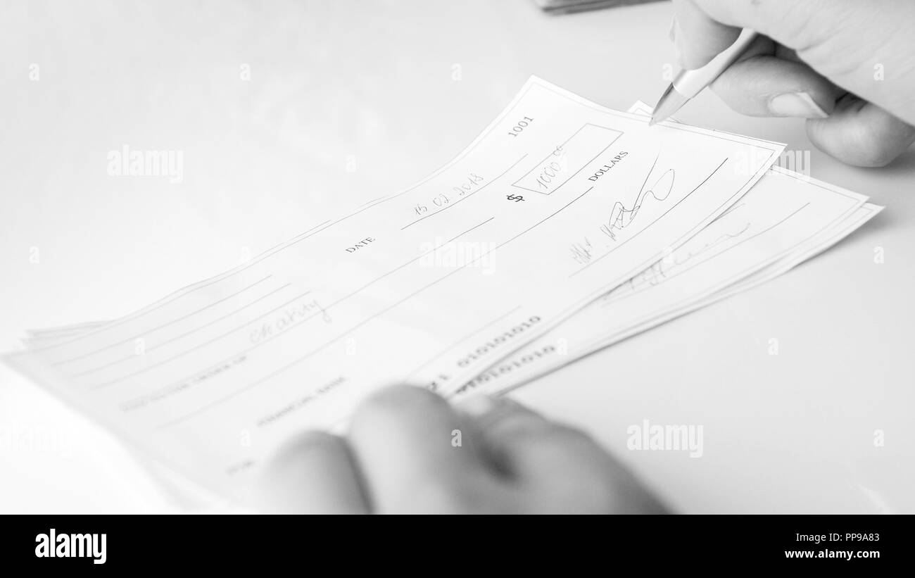 Immagine in bianco e nero di donna iscritto il pagamento con assegno bancario Foto Stock