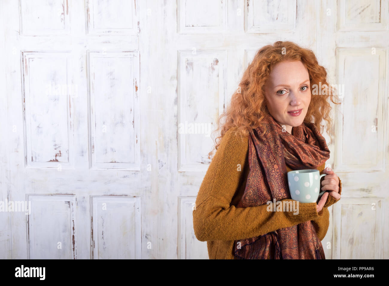 Bellissimi i capelli rossi donna tenendo la tazza di caffè Foto Stock