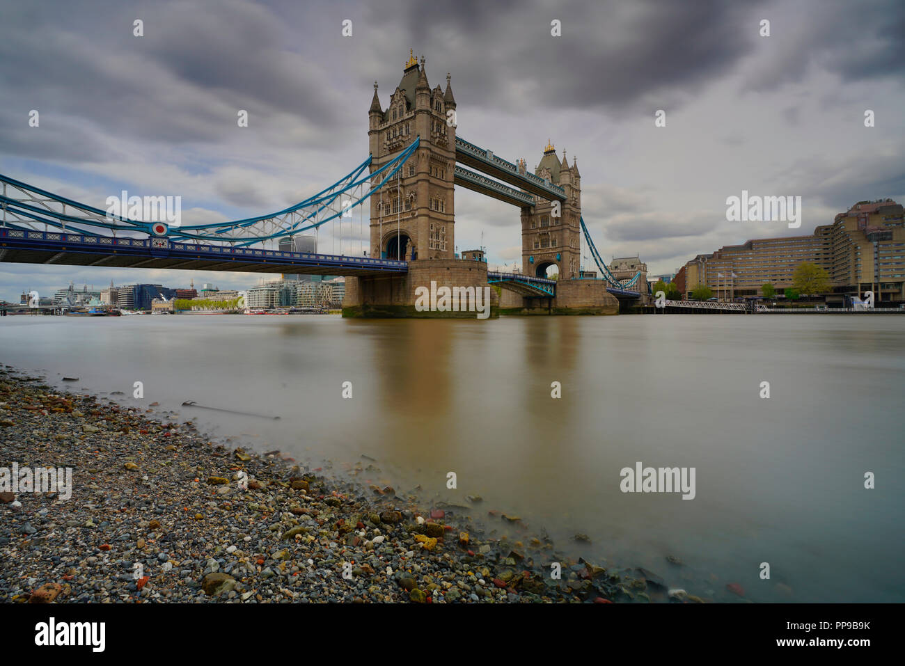 Una vista del Tower Bridge di Londra con nuvoloso cielo scuro in background Foto Stock