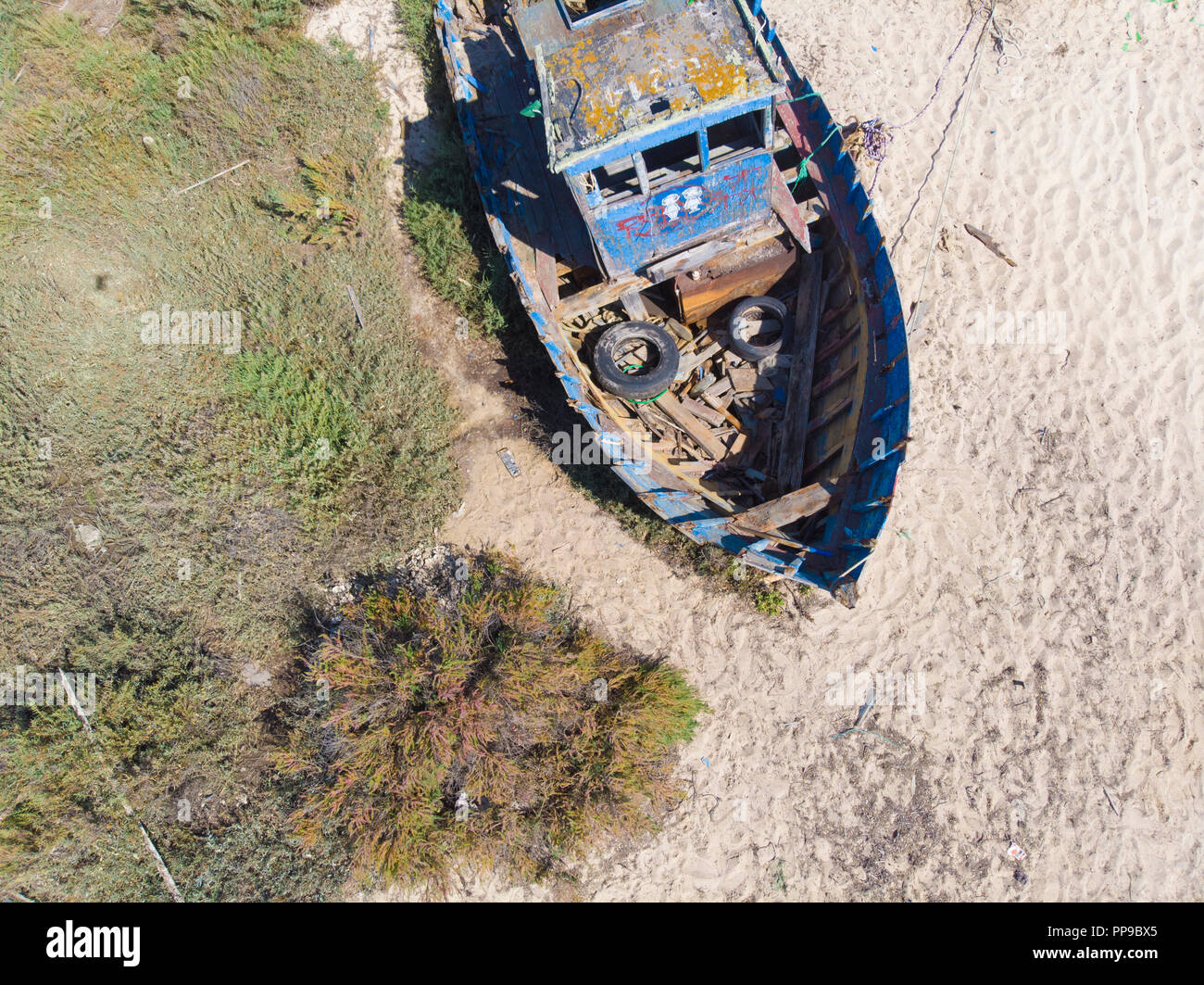 Vecchio abbandonato la pesca in barca Spiaggiata a bassa marea sul fiume Sado Foto Stock